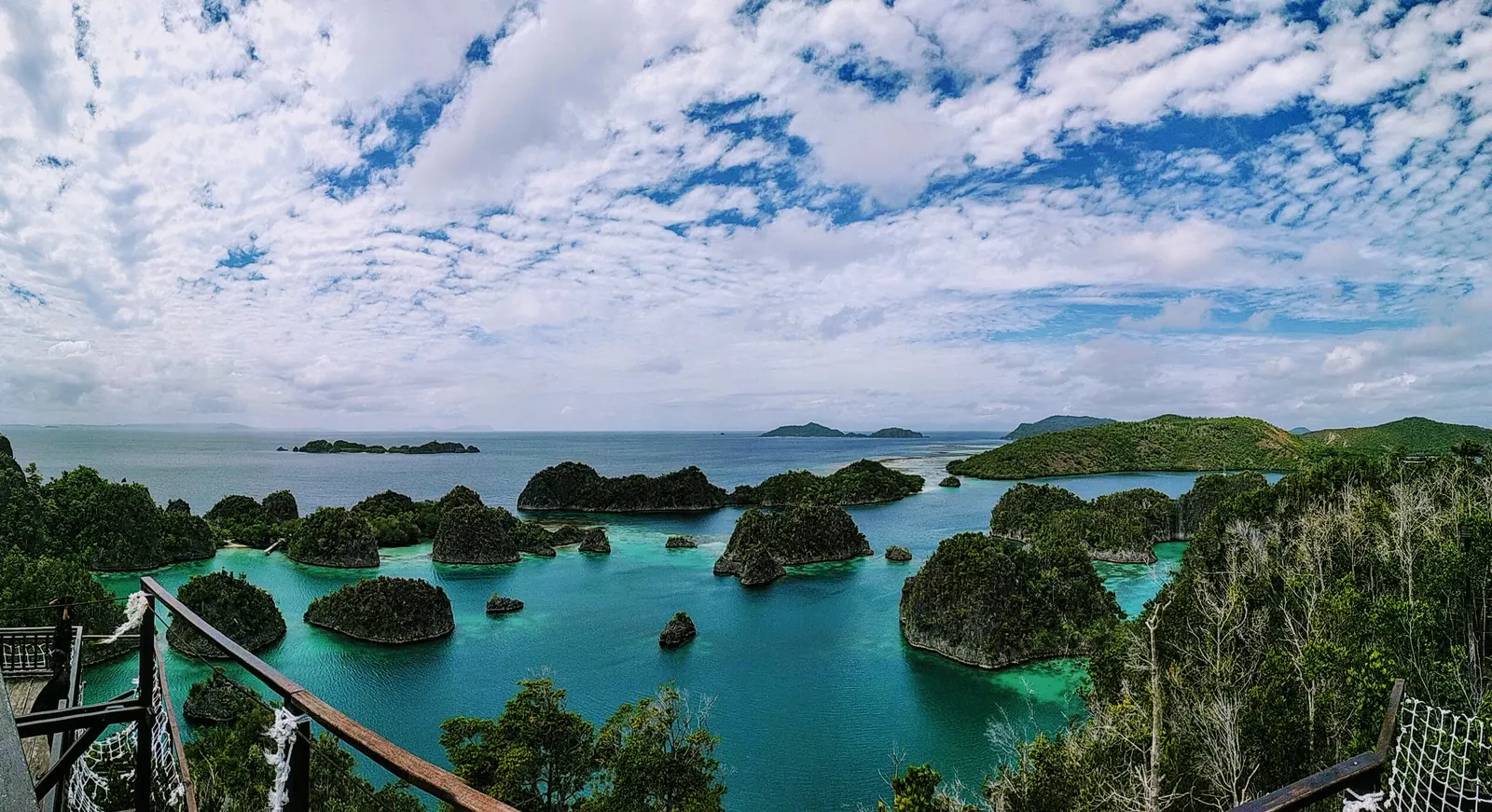 Gugusan pulau karst hijau dan perairan biru Piaynemo, dilihat dari titik pandang berpagar